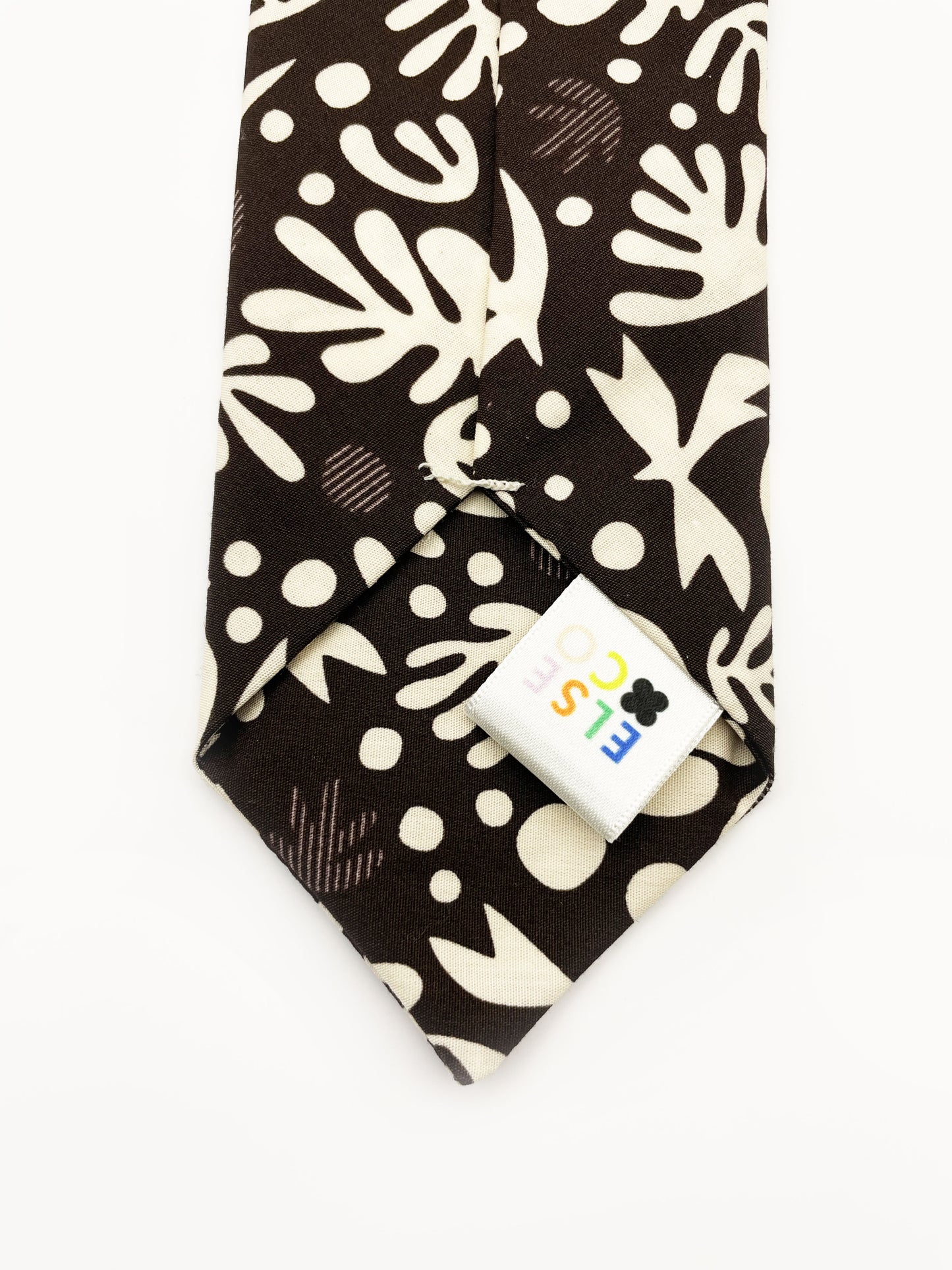 A cotton necktie with cream-colored birds and abstract shapes.