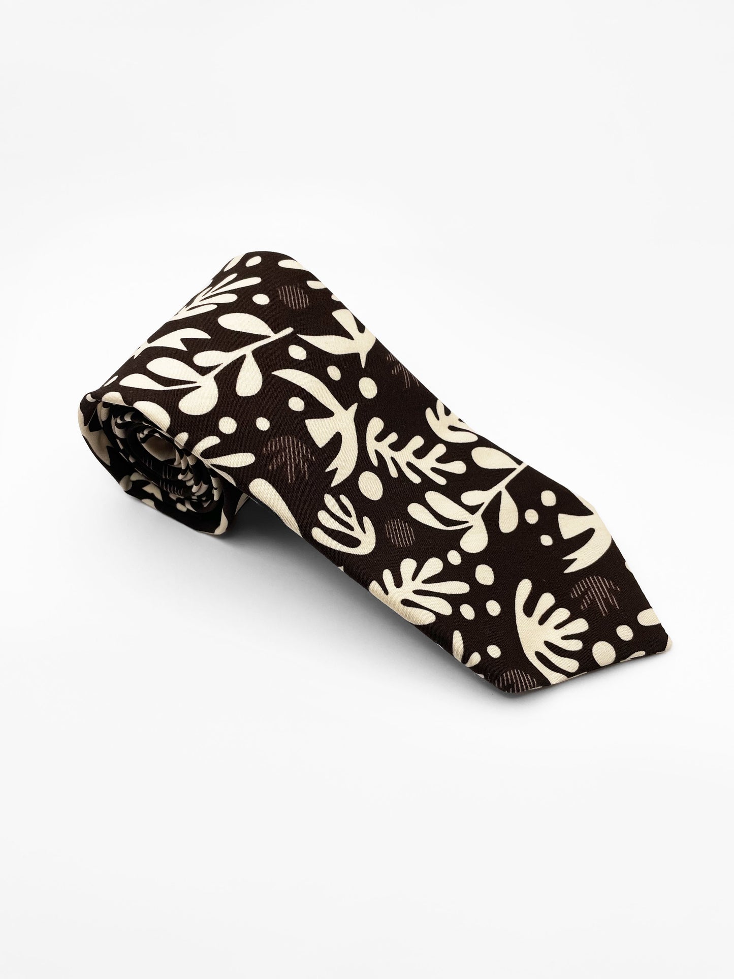A cotton necktie with cream-colored birds and abstract shapes.