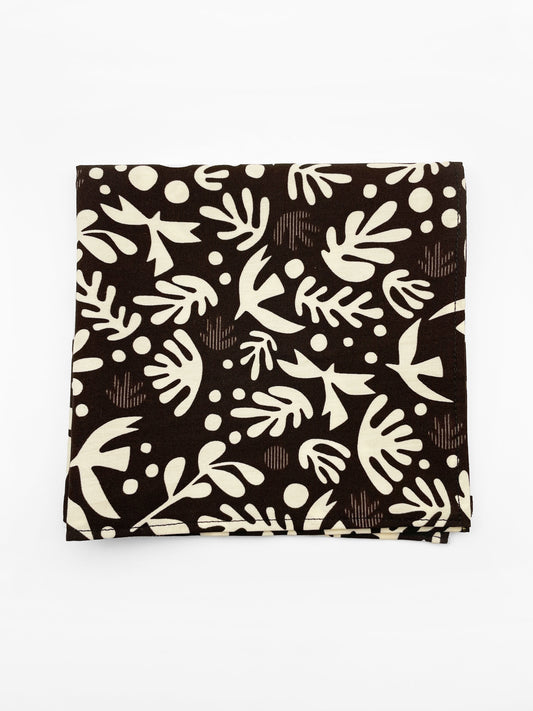 A cotton handmade pocket square with cream-colored birds and abstract shapes.