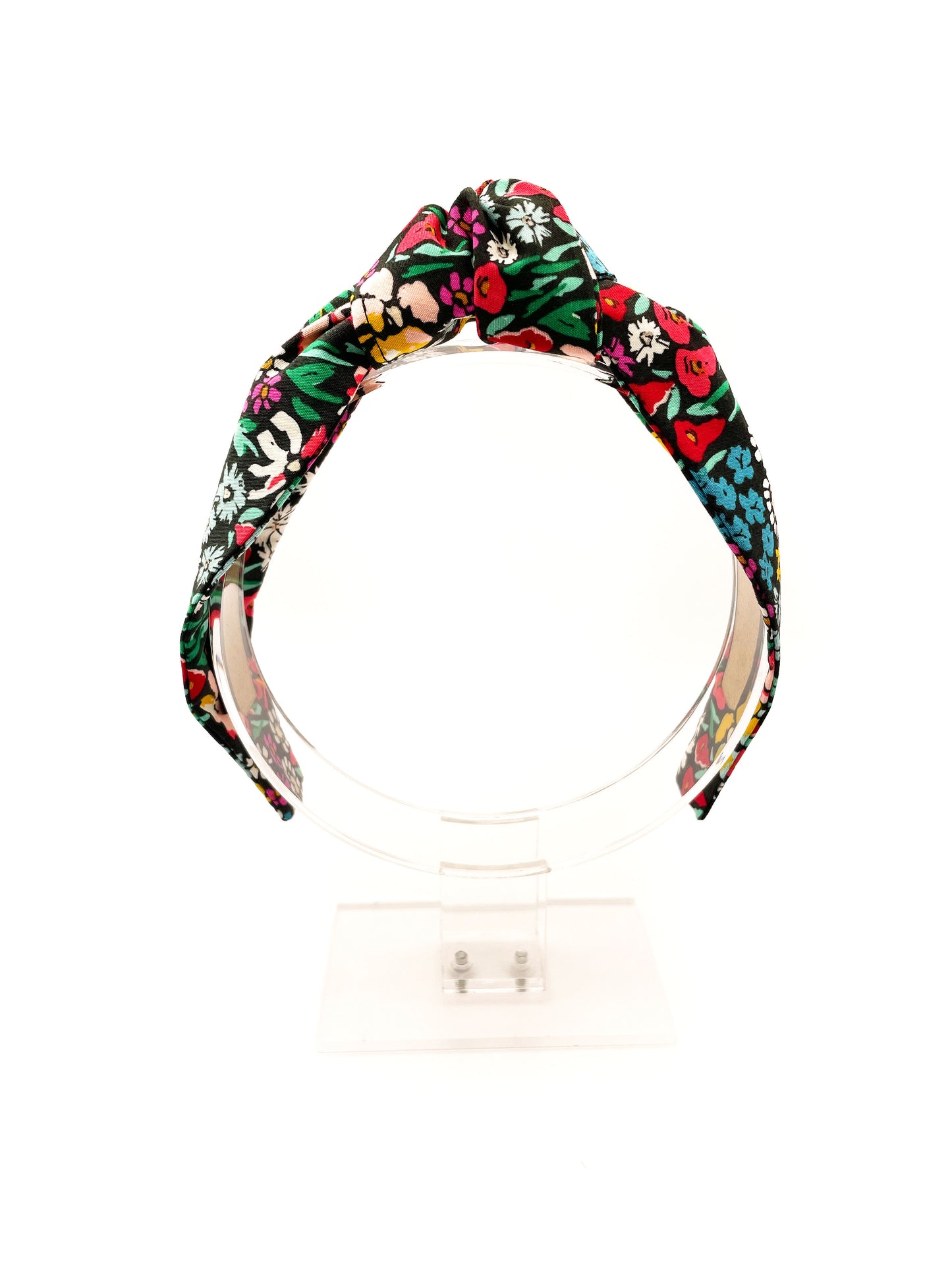 A black handmade knotted headband with a colorful floral print.