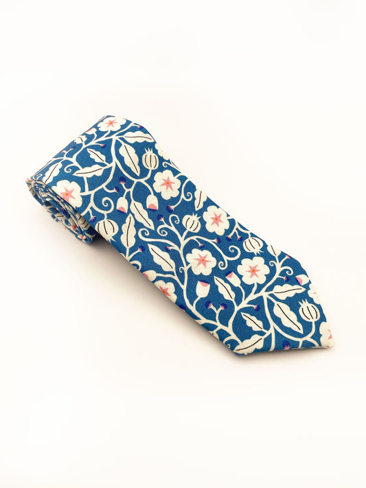 A blue necktie with white flowers that have pink centers.