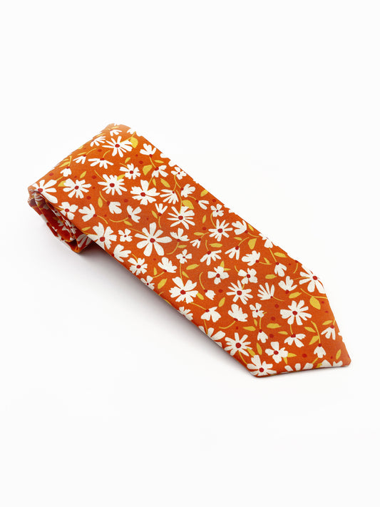 A handmade necktie with a warm and earthy color palette, featuring hues of rust, golden brown, and soft neutrals.