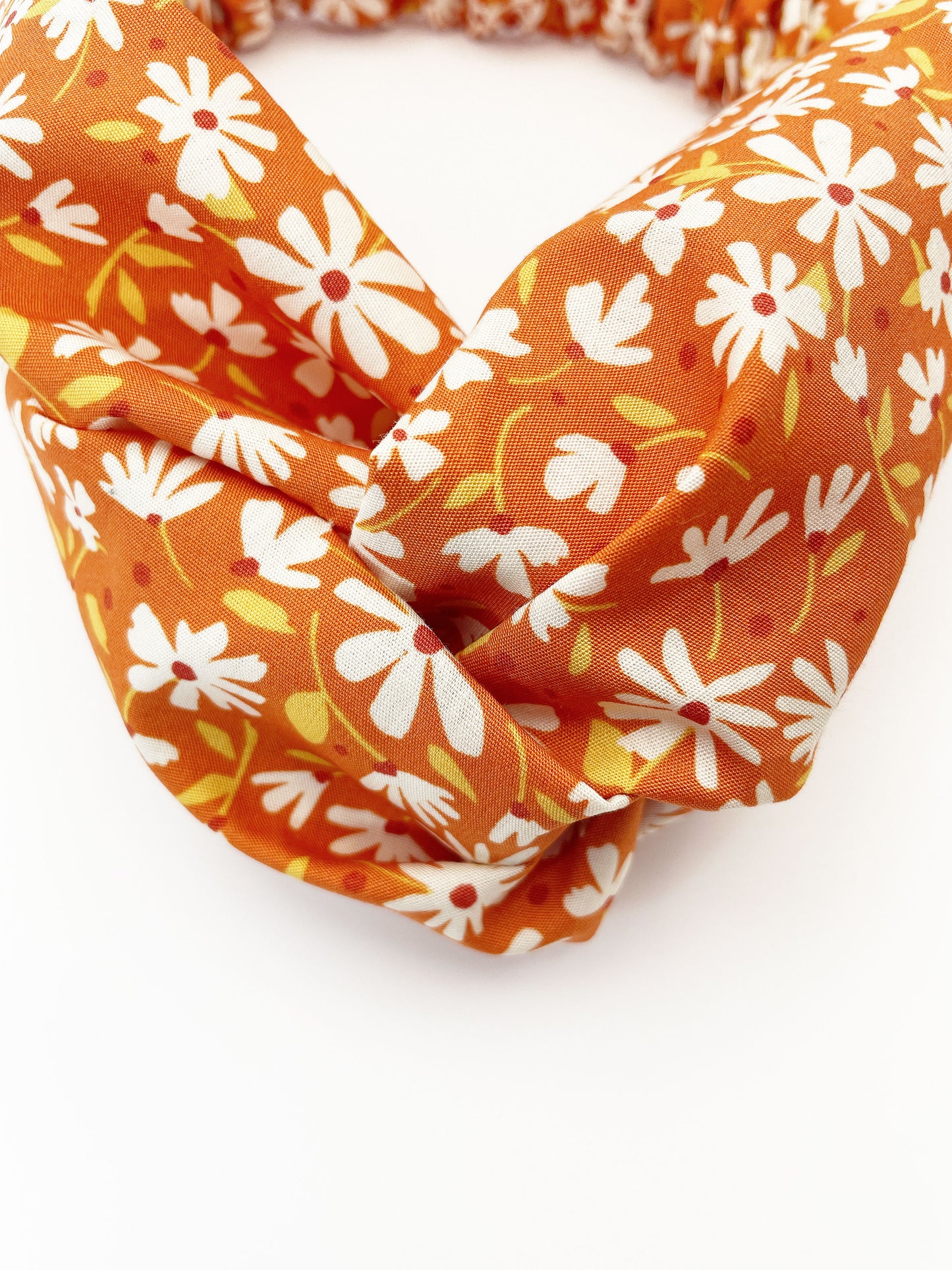 A handmade brown twist headband with off white flowers.