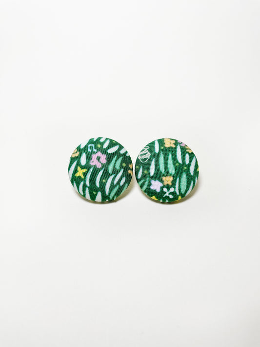 Handmade green fabric covered post earrings with a grass print.