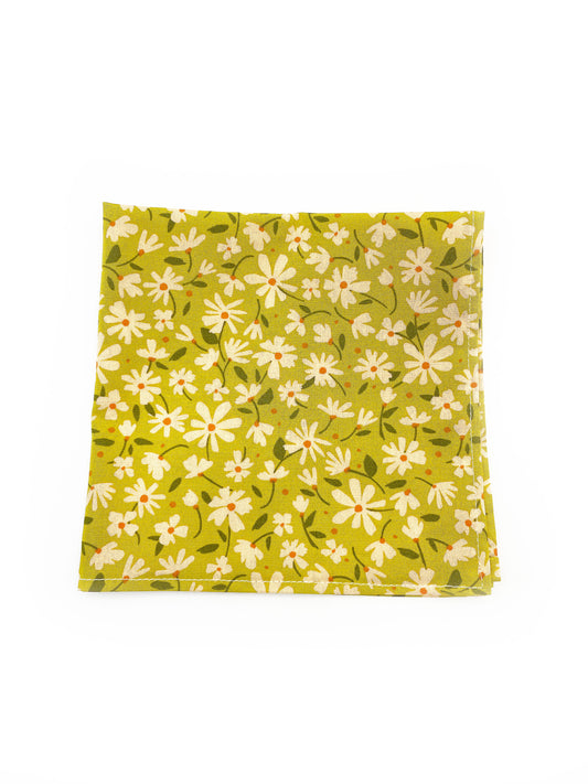 A mossy green floral pocket square with cream flowers, showcasing shades of earthy browns and pops of warm peach and blush pink.