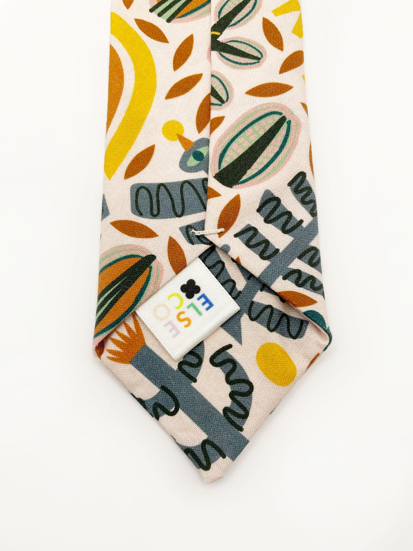 A necktie featuring a bold nature-inspired print of bugs, plants, suns, and rainbows. The color palette includes muted mustard, gentle gray, and soft pastels.