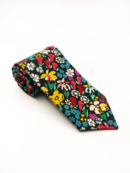 A handmade black necktie with vibrant multi-colored flowers.