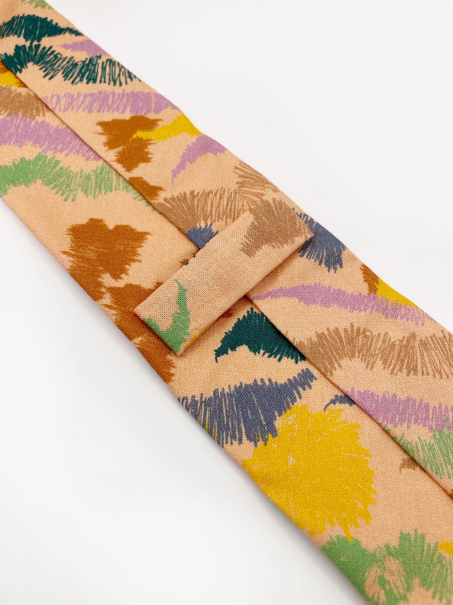A necktie crafted from high-quality cotton with an abstract design inspired by the rolling hills and earthy tones of the desert.