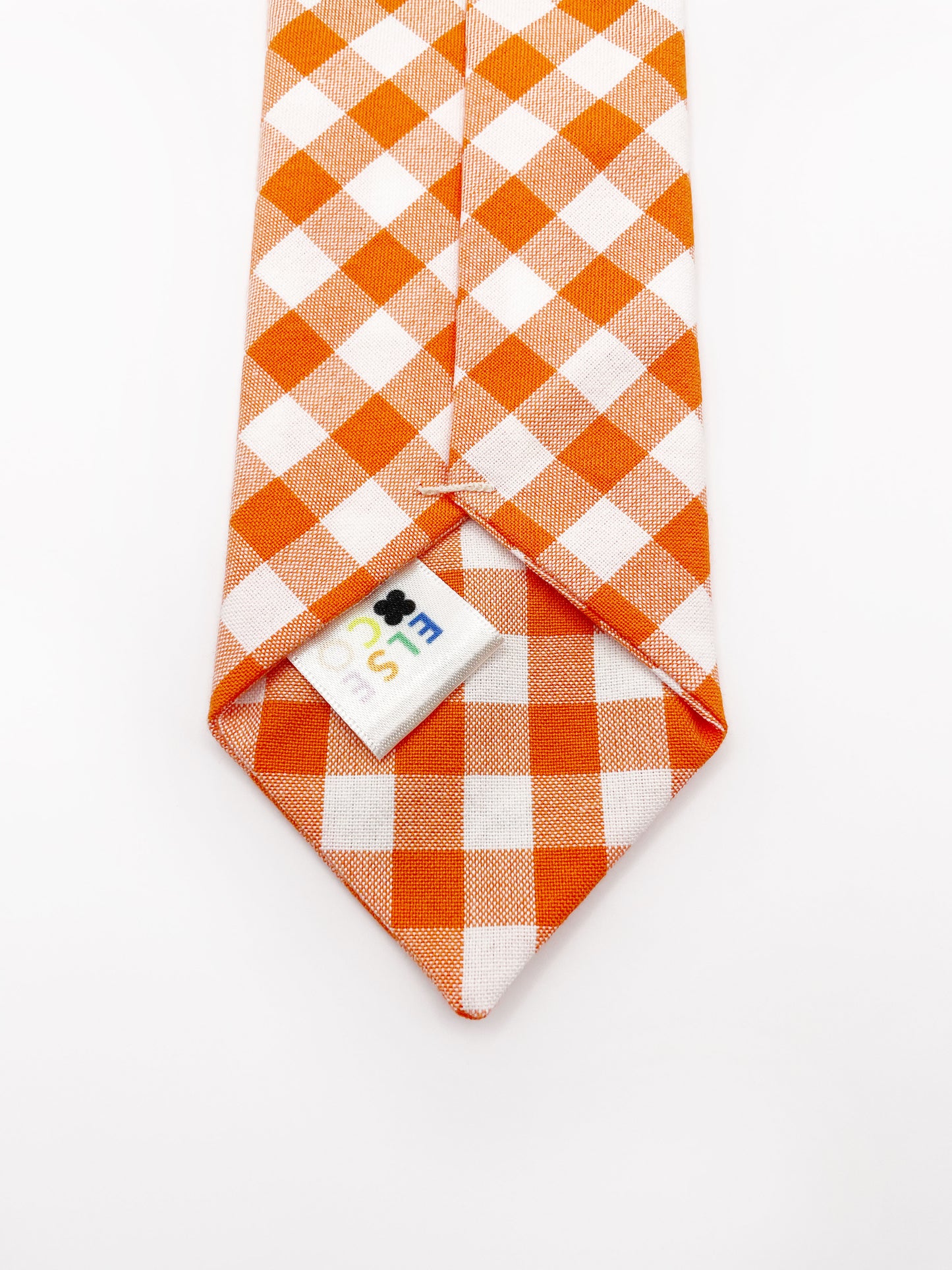 A cotton necktie with an orange and white gingham plaid print.