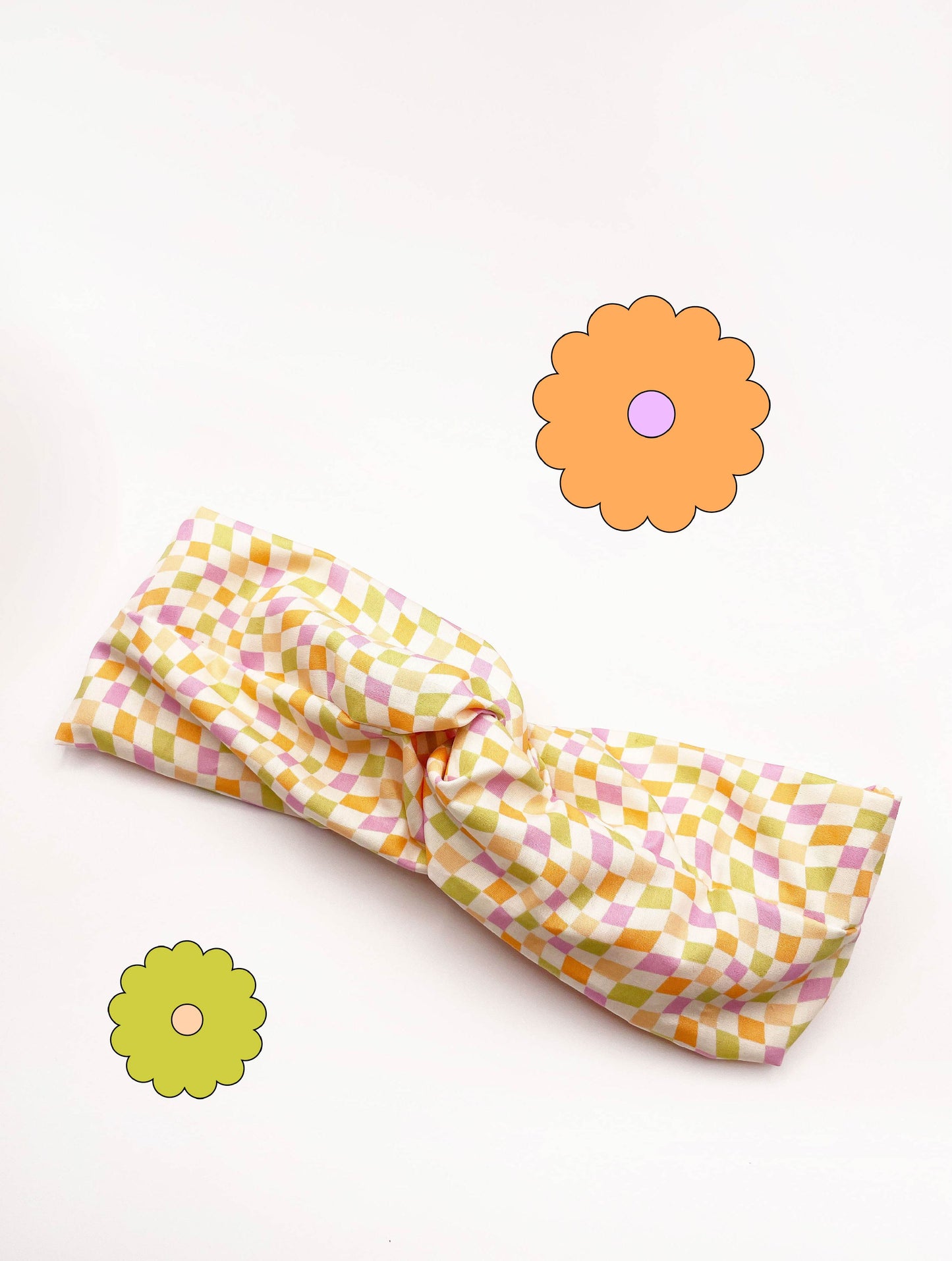 A handmade twist headband with a pastel checkered print.