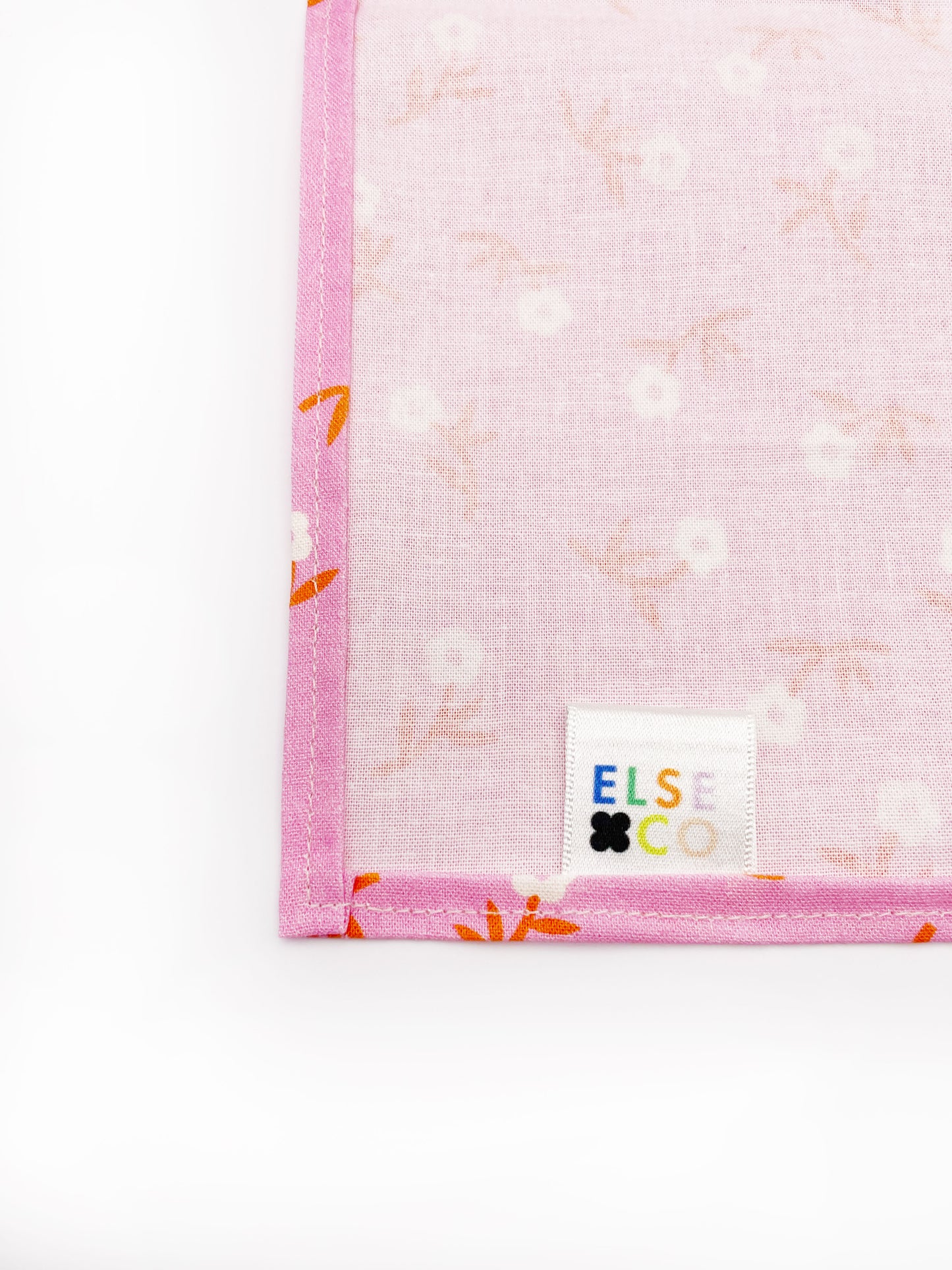 A cheerful pink pocket square with orange-stemmed flowers.