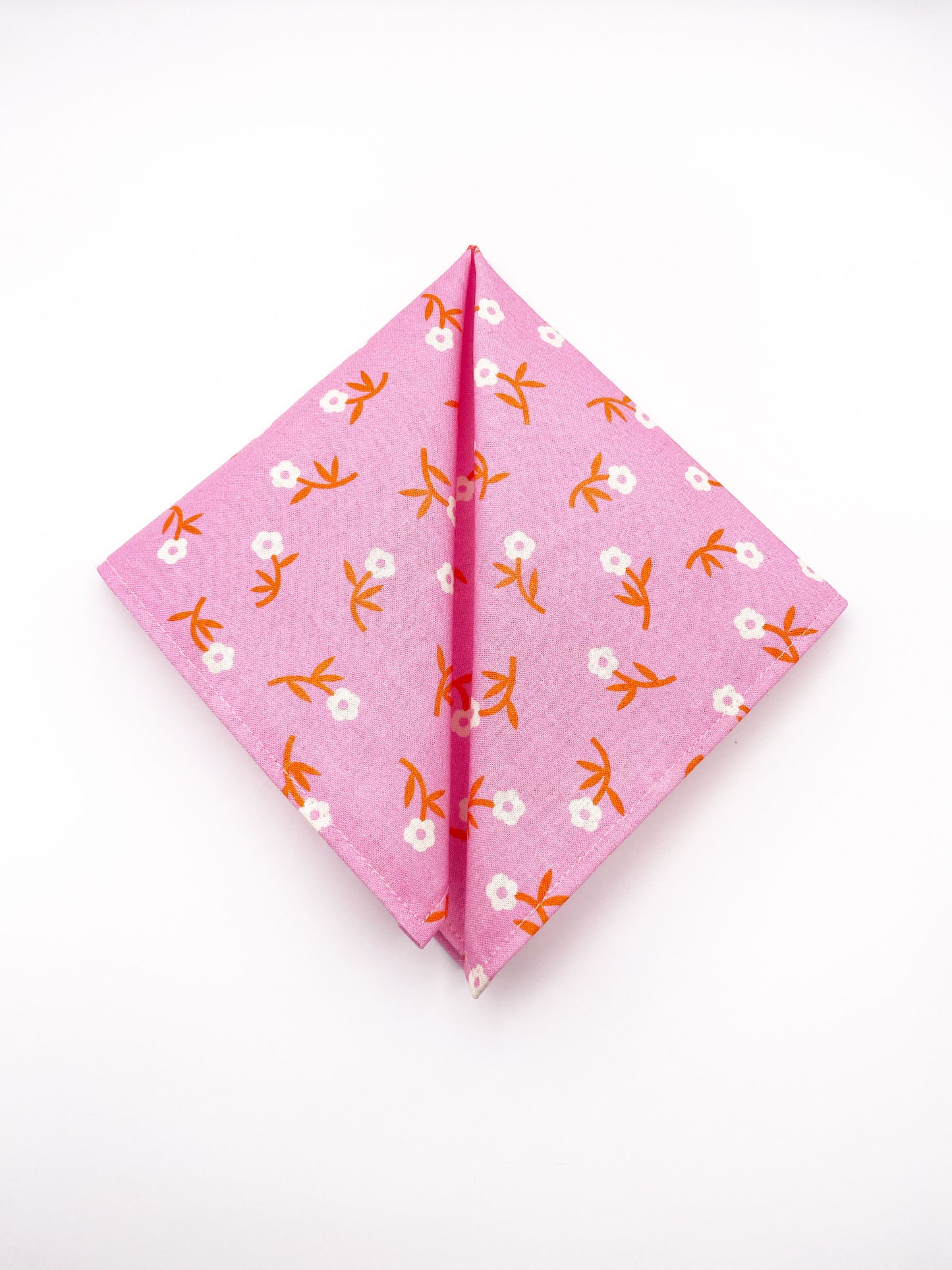 A cheerful pink pocket square with orange-stemmed flowers.
