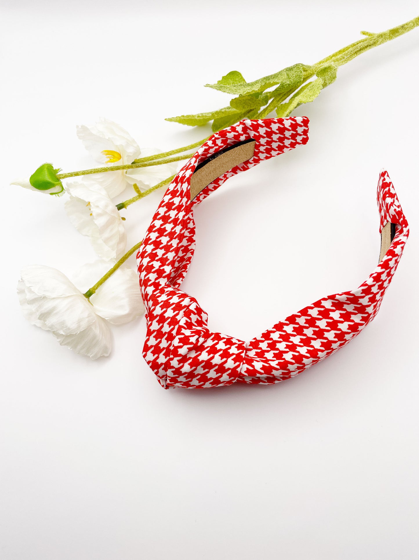 A handmade red houndstooth knotted headband.