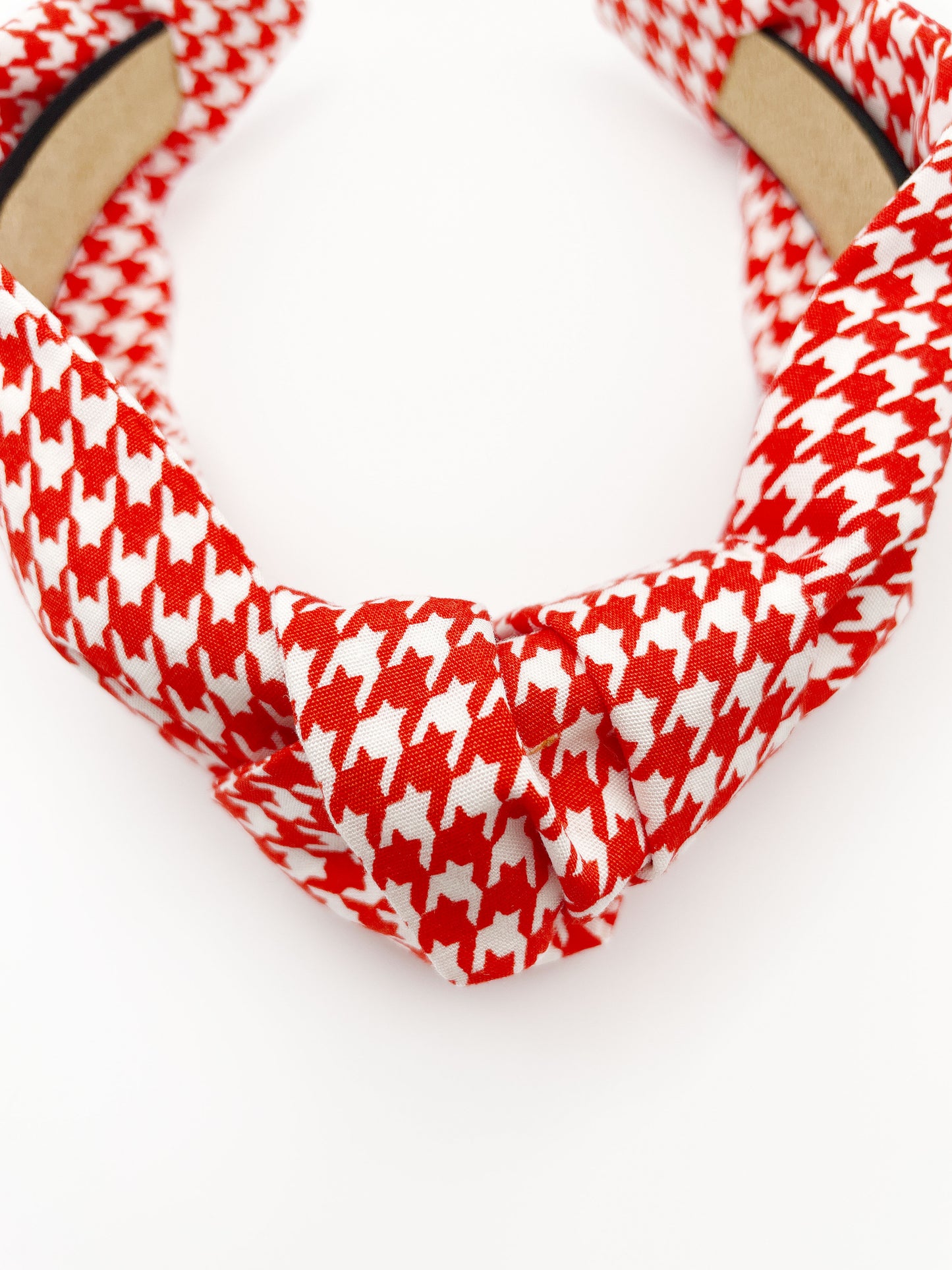 A handmade red houndstooth knotted headband.