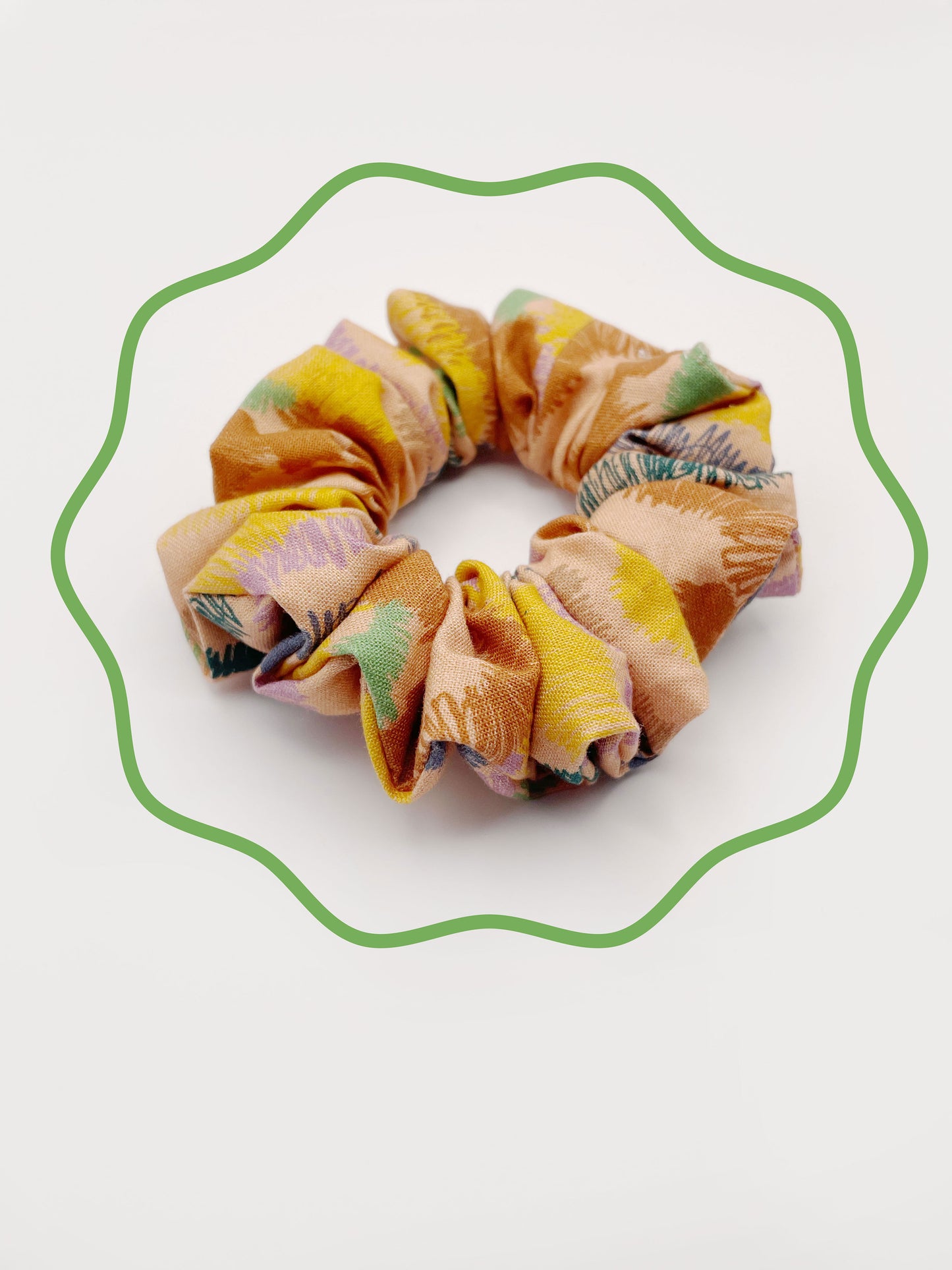 A scrunchie crafted from high-quality cotton with an abstract design inspired by the rolling hills and earthy tones of the desert.