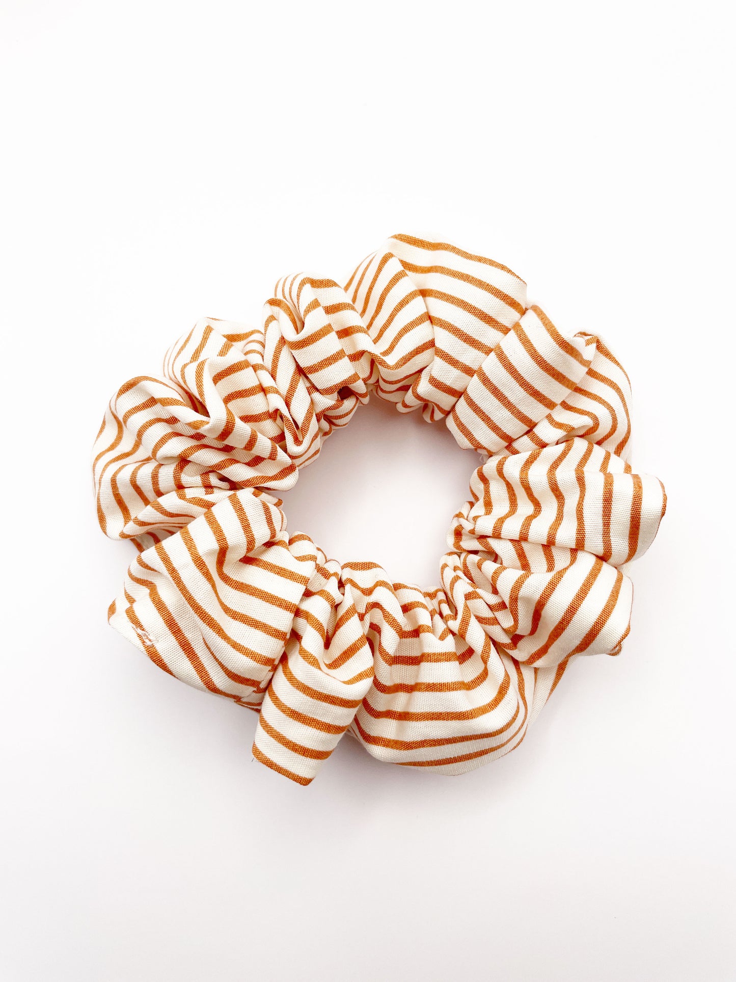 A handmade copper striped boho scrunchie.