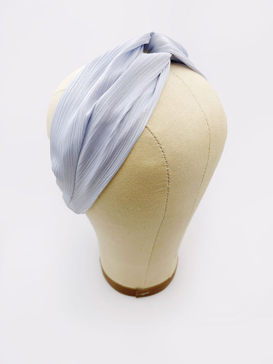 A twist headband made with a light sky blue crinkle satin fabric. The headband is on a mannequin head.
