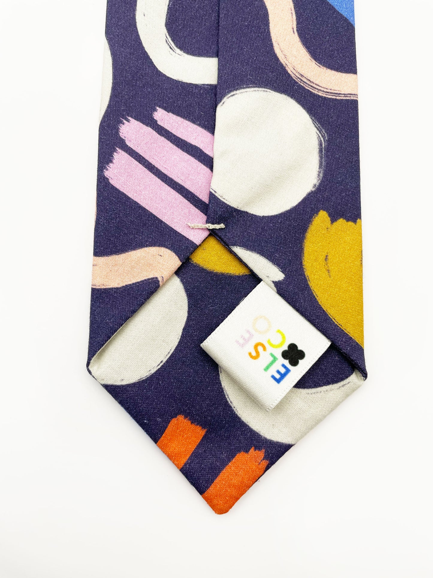 A cotton necktie with a colorful abstract print featuring various doodles.