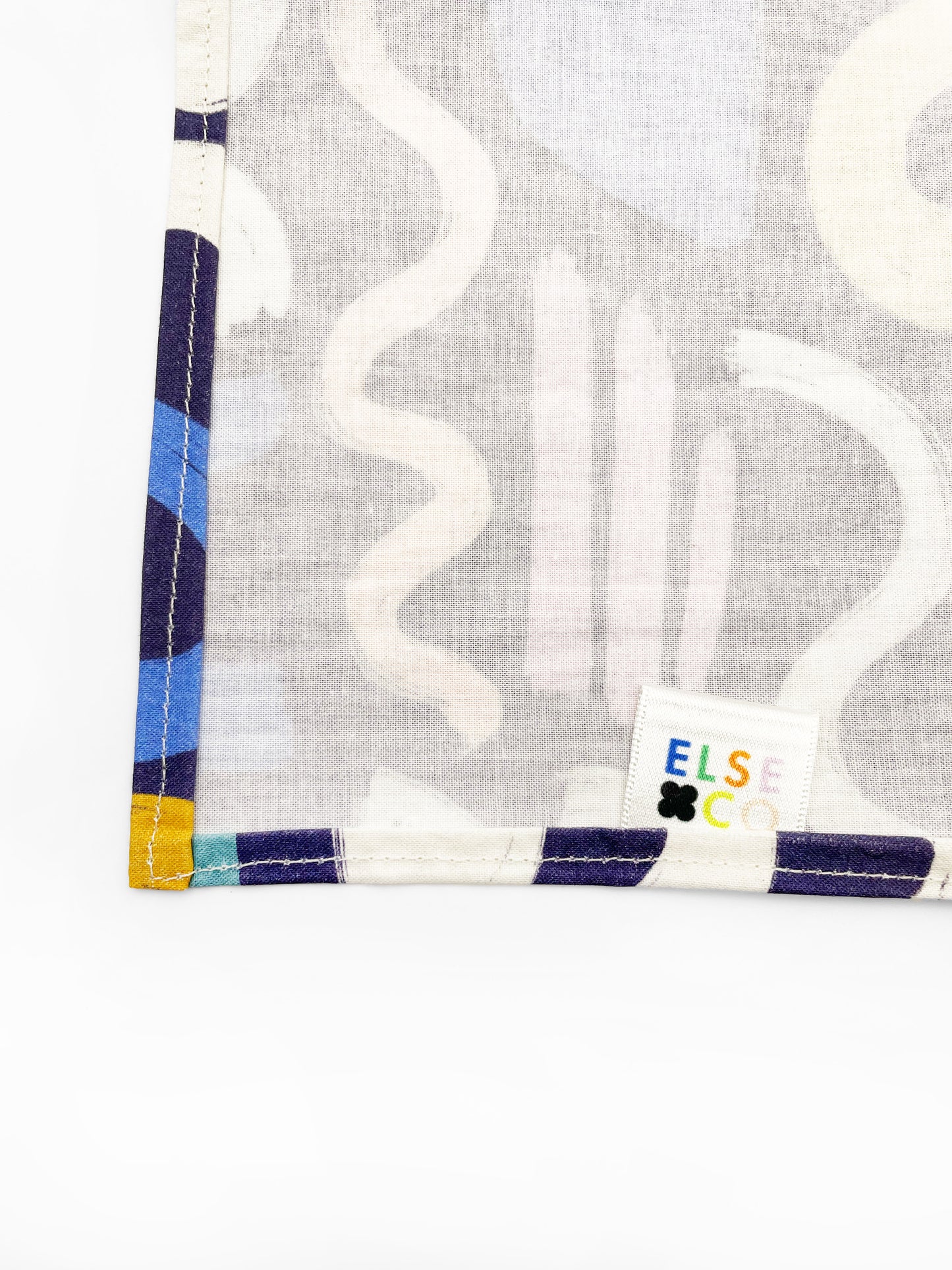A cotton handmade pocket square with a colorful abstract print featuring various doodles.
