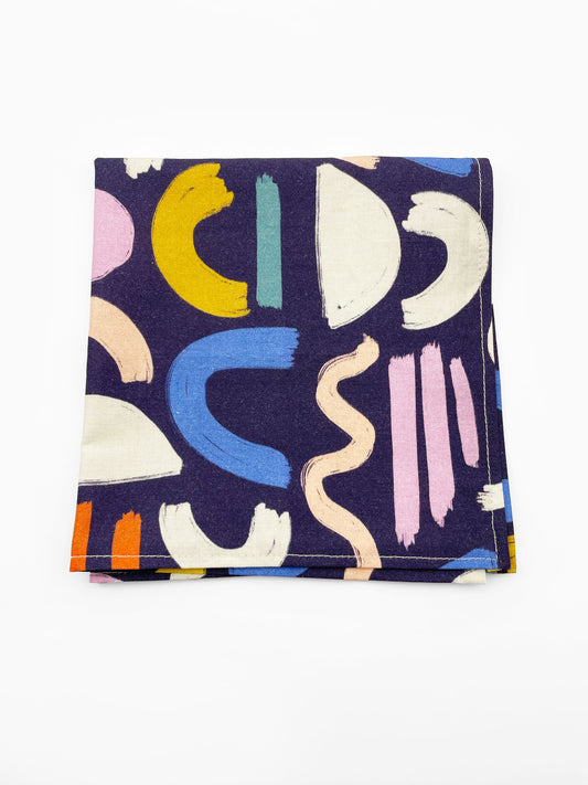 A cotton handmade pocket square with a colorful abstract print featuring various doodles.