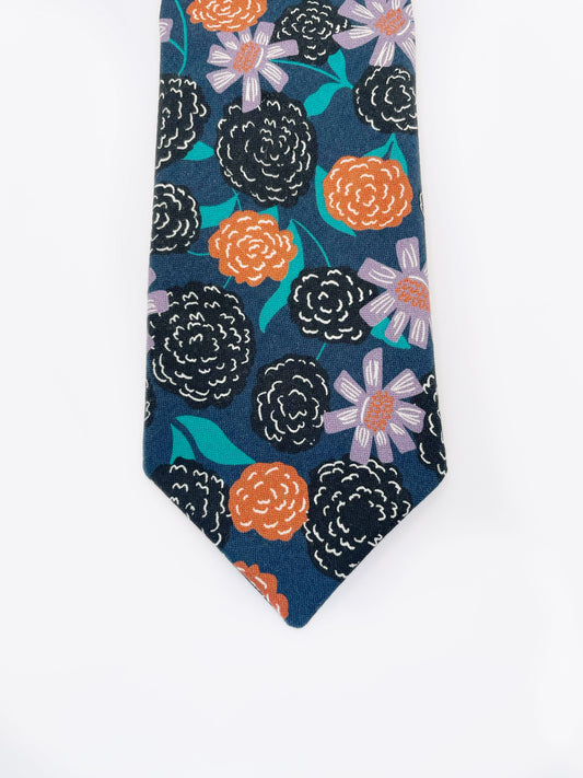 A navy blue necktie with vivid orange, lavender, and black flowers, accented with fresh green leaves.