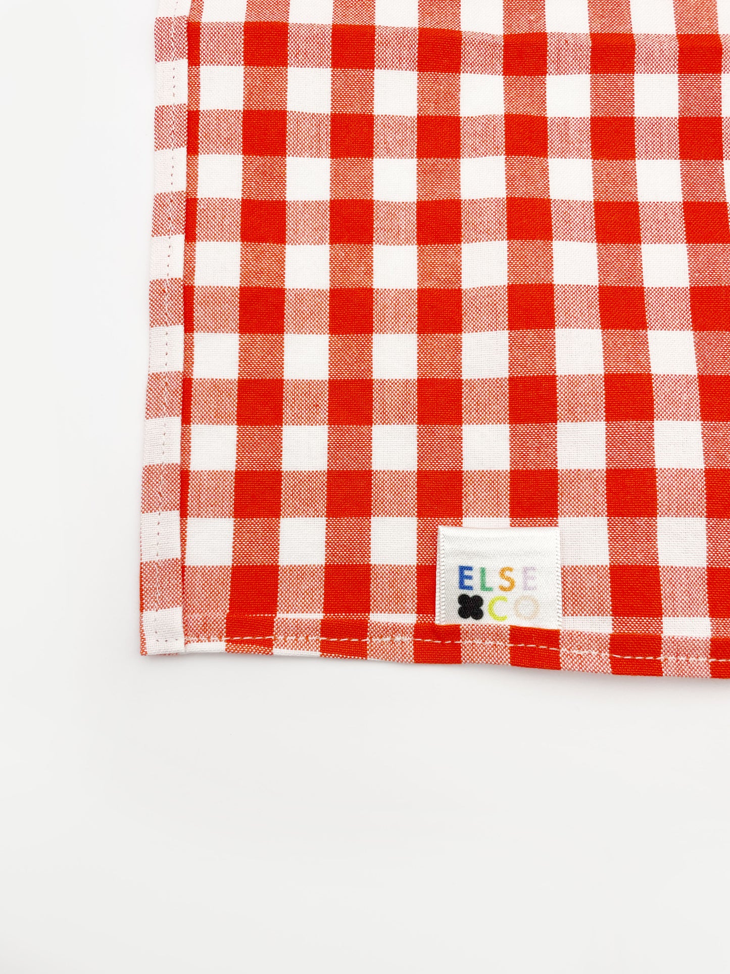 A cotton handmade pocket square with a red gingham plaid print.