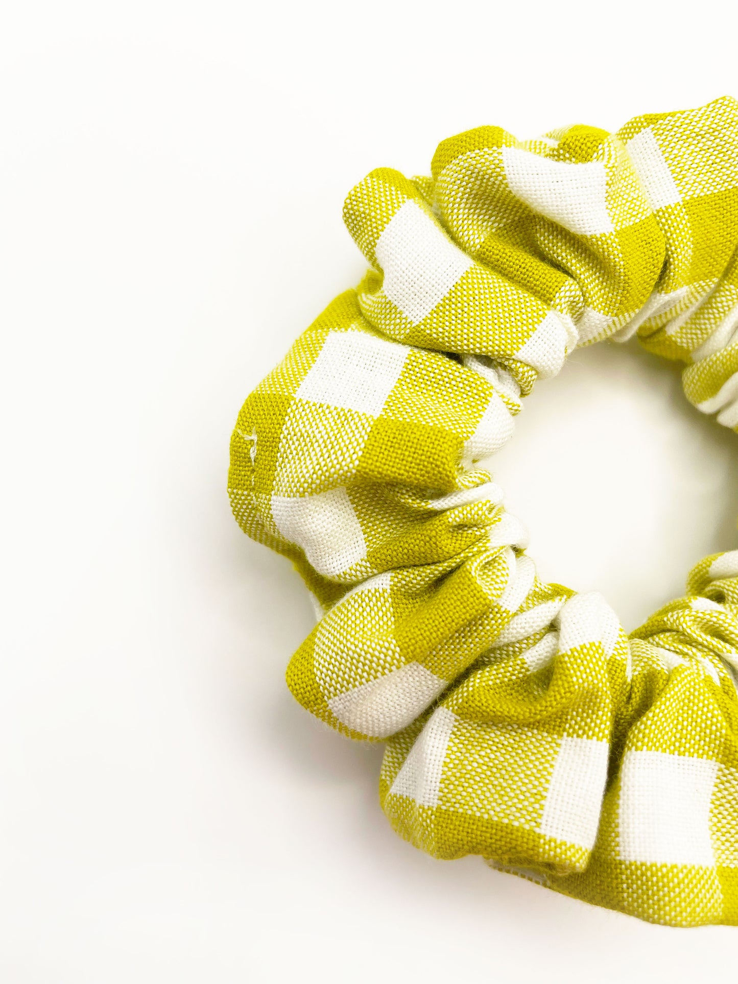 A green and white gingham plaid scrunchie.