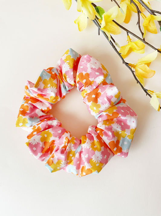 A handmade colorful floral scrunchie.