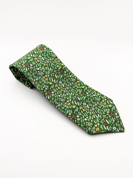 A handmade green floral necktie with grass print.