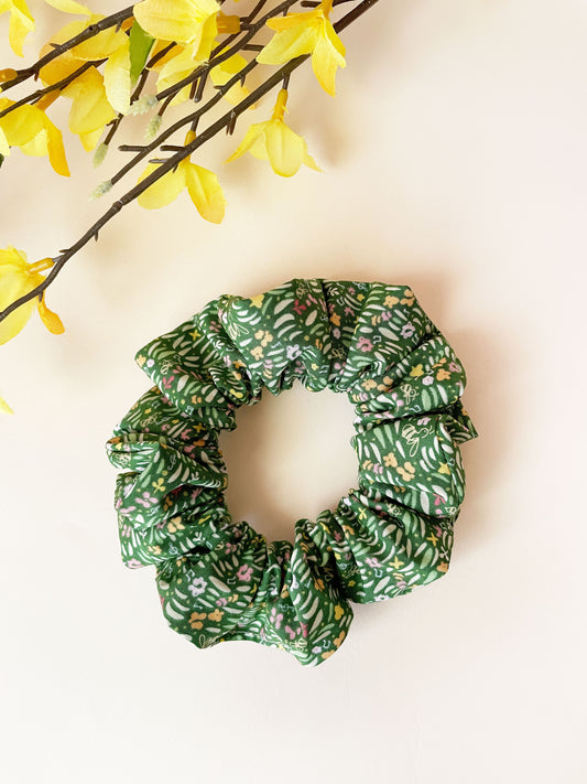 A handmade green floral scrunchie with grass print.
