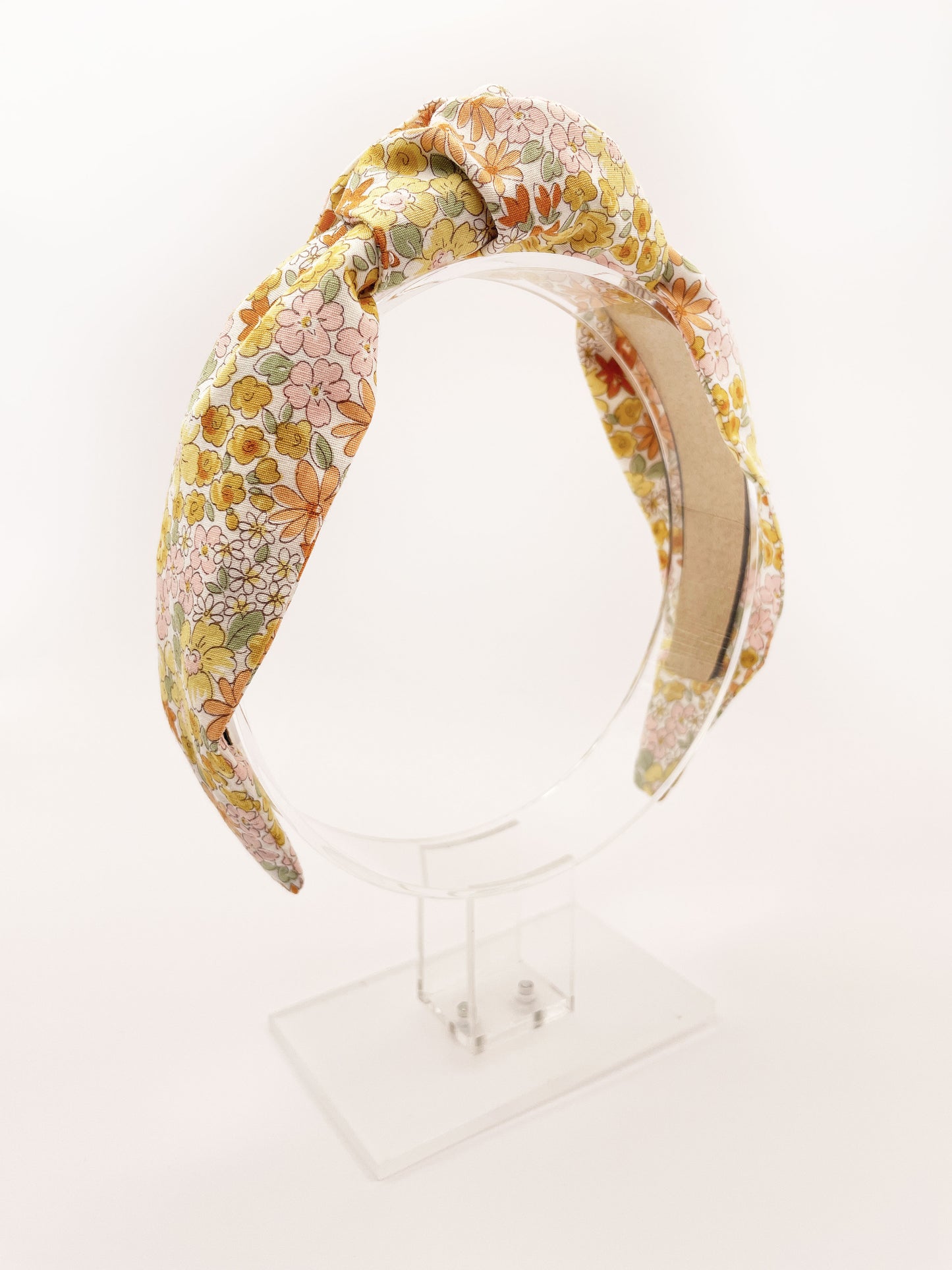 Handmade knotted headband with yellow flowers against an off white background