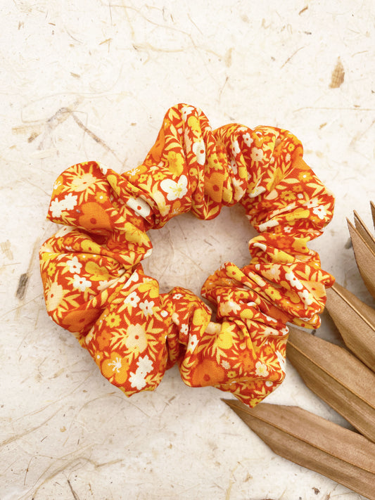 An orange scrunchie with a colorful ditsy floral print.