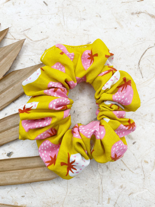 A yellow handmade scrunchie with an ivory and pink strawberry print.