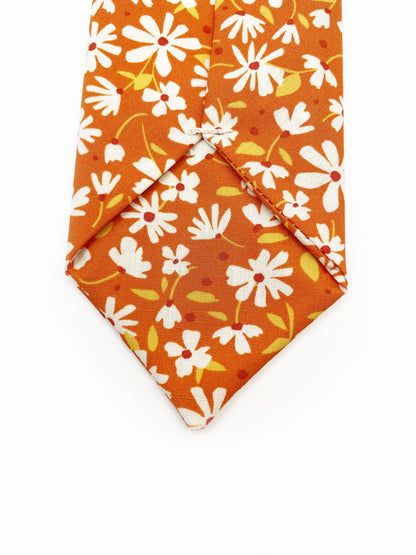 A handmade necktie with a warm and earthy color palette, featuring hues of rust, golden brown, and soft neutrals. 