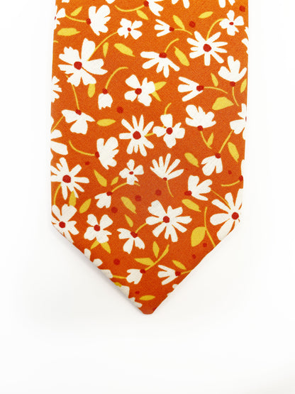 A handmade necktie with a warm and earthy color palette, featuring hues of rust, golden brown, and soft neutrals. 