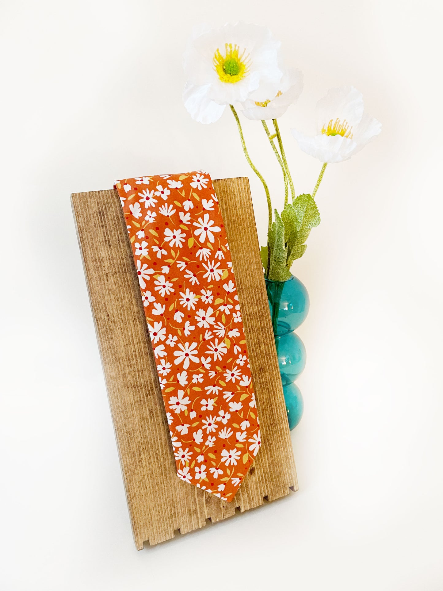 A handmade necktie with a warm and earthy color palette, featuring hues of rust, golden brown, and soft neutrals. 