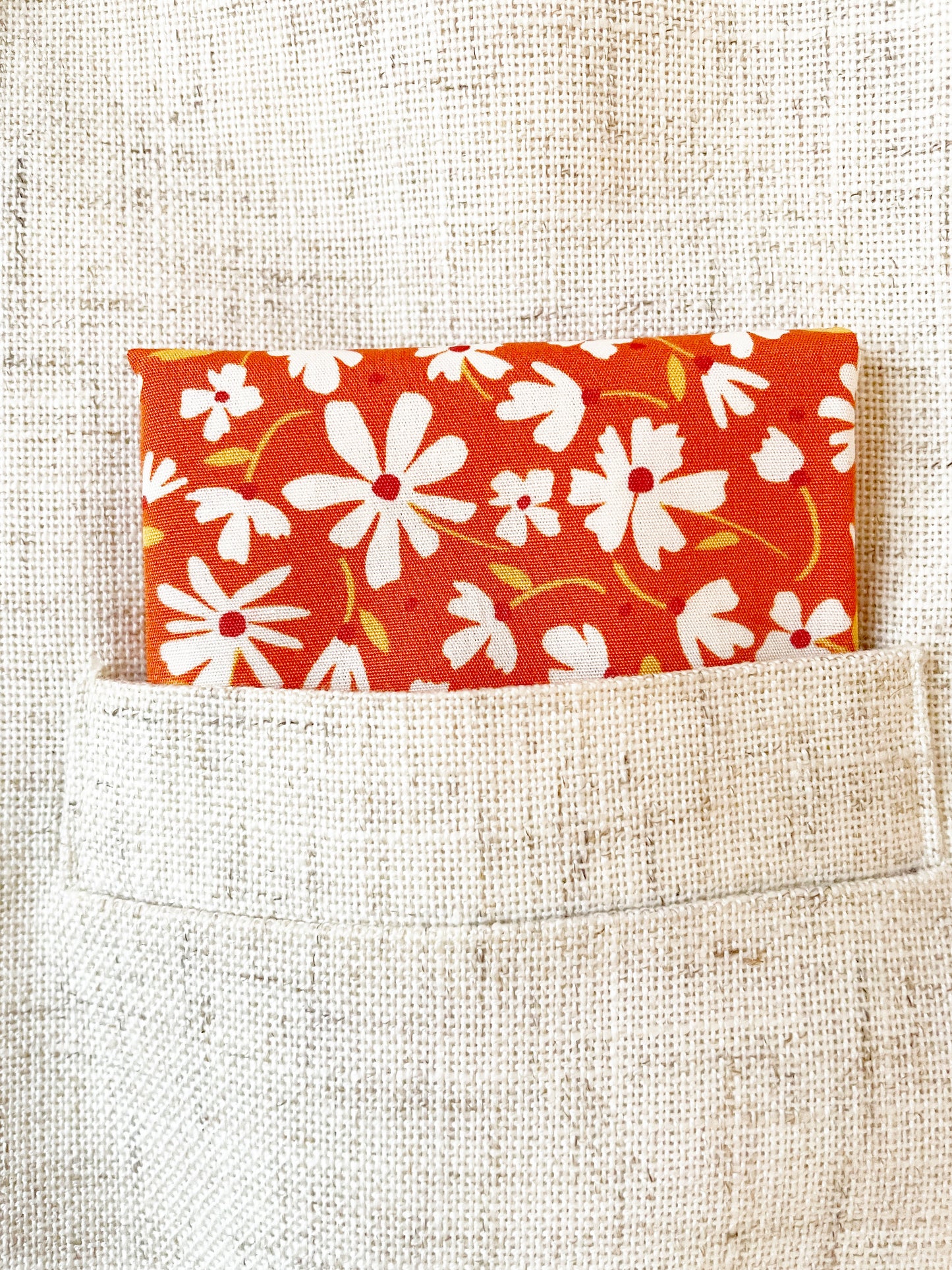 A rust brown floral pocket square with white flowers, showcasing shades of earthy browns and pops of warm peach and blush pink. 