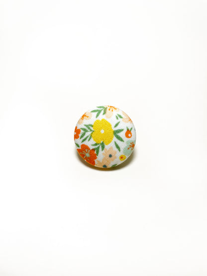 Handmade ditsy floral fabric covered lapel pin.