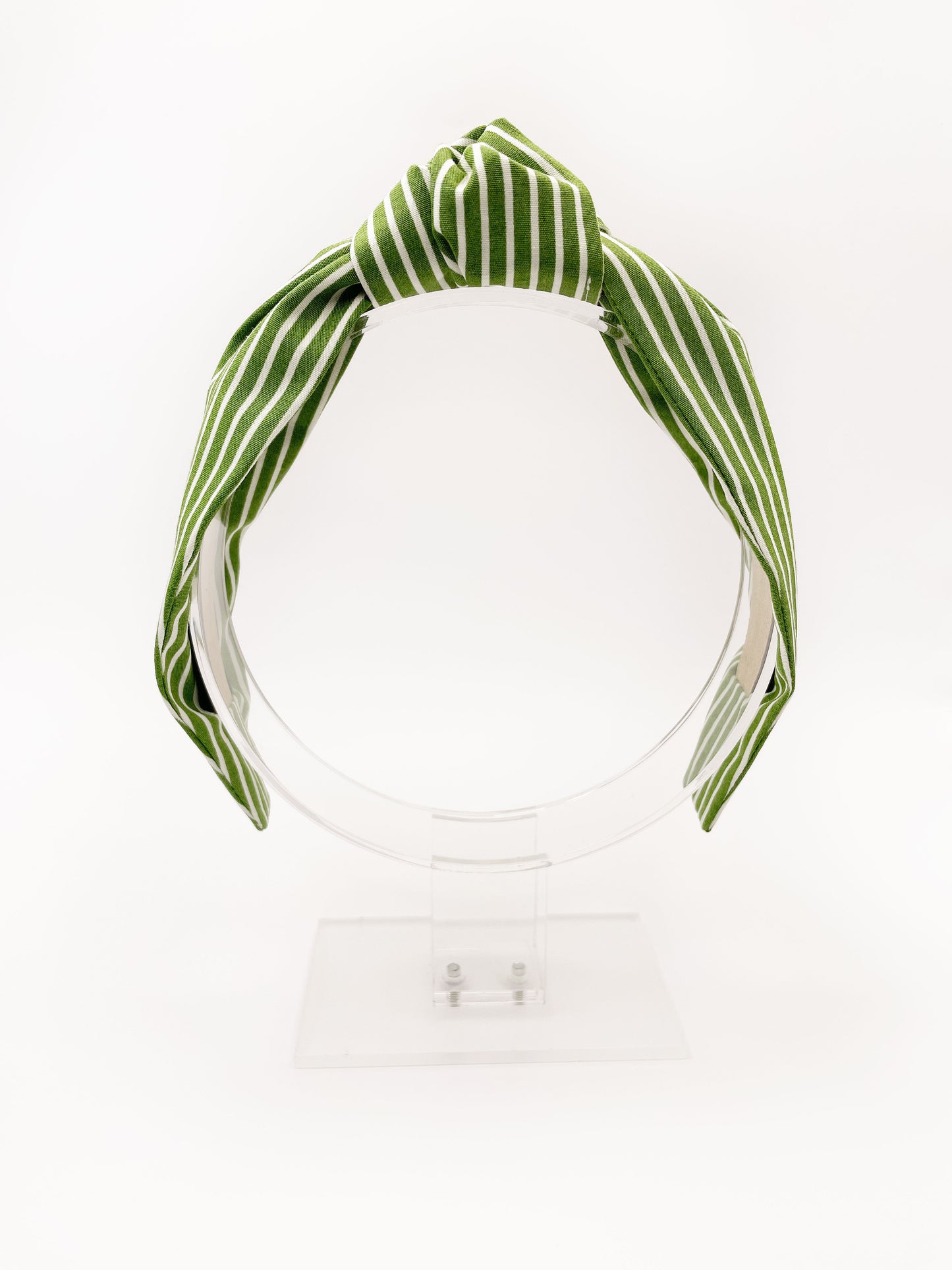 A handmade knotted headband featuring a white striped print against a moss green background.