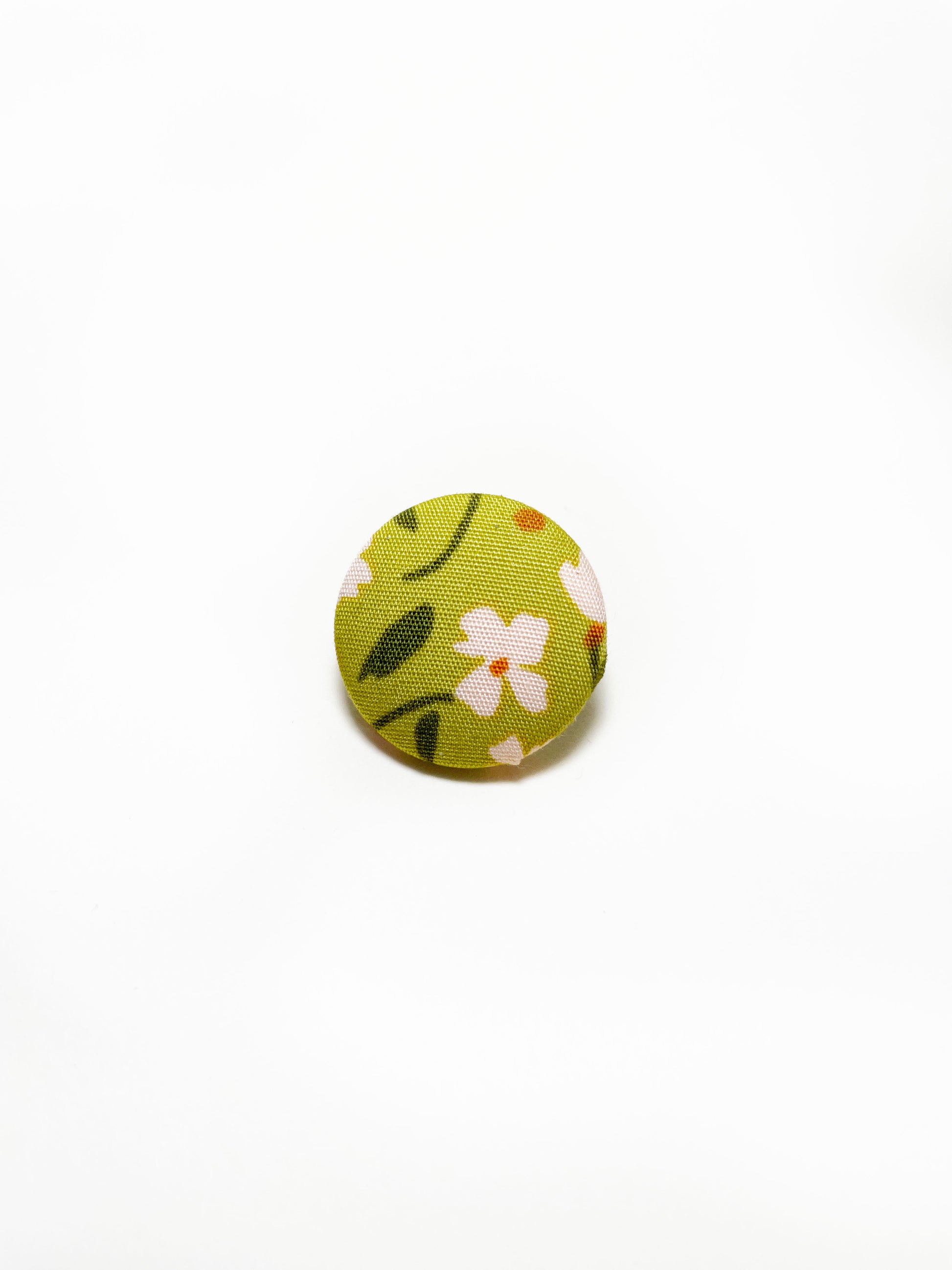 Handmade green floral fabric covered lapel pin.