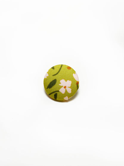 Handmade green floral fabric covered lapel pin.