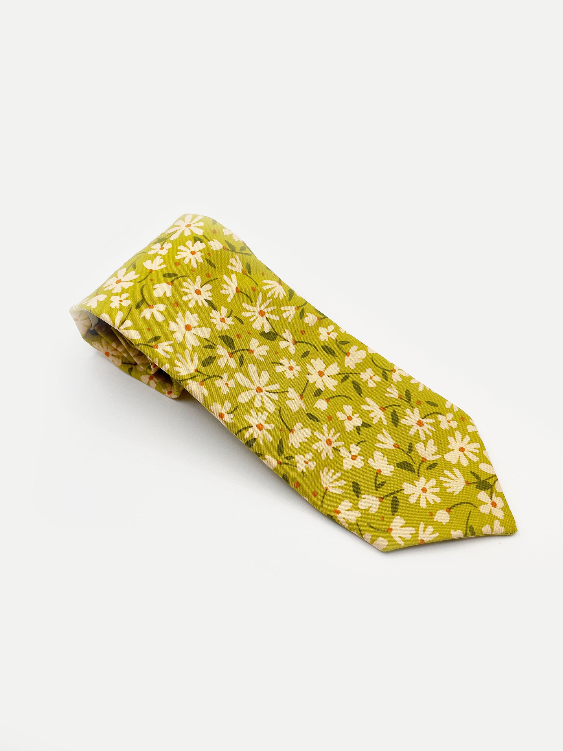 A mossy green handmade necktie with cream flowers, showcasing shades of earthy browns and pops of warm peach and blush pink.