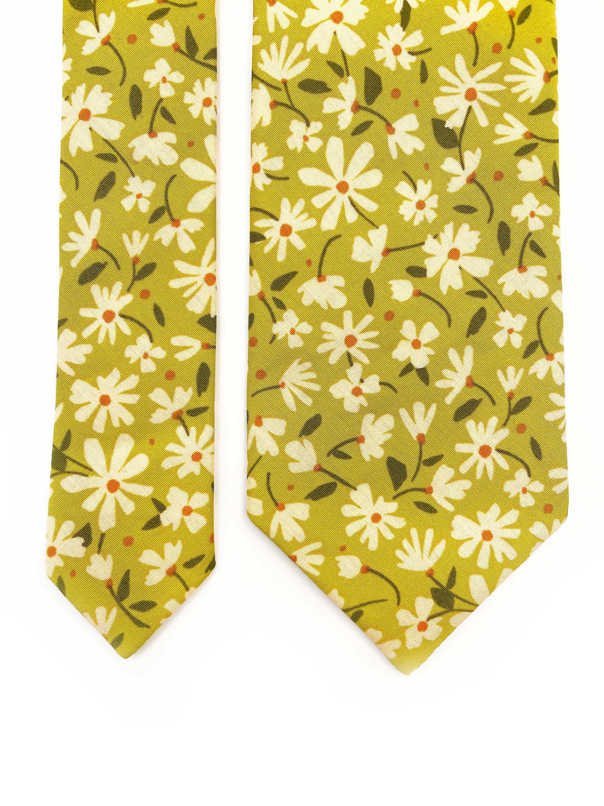 A mossy green handmade necktie with cream flowers, showcasing shades of earthy browns and pops of warm peach and blush pink.