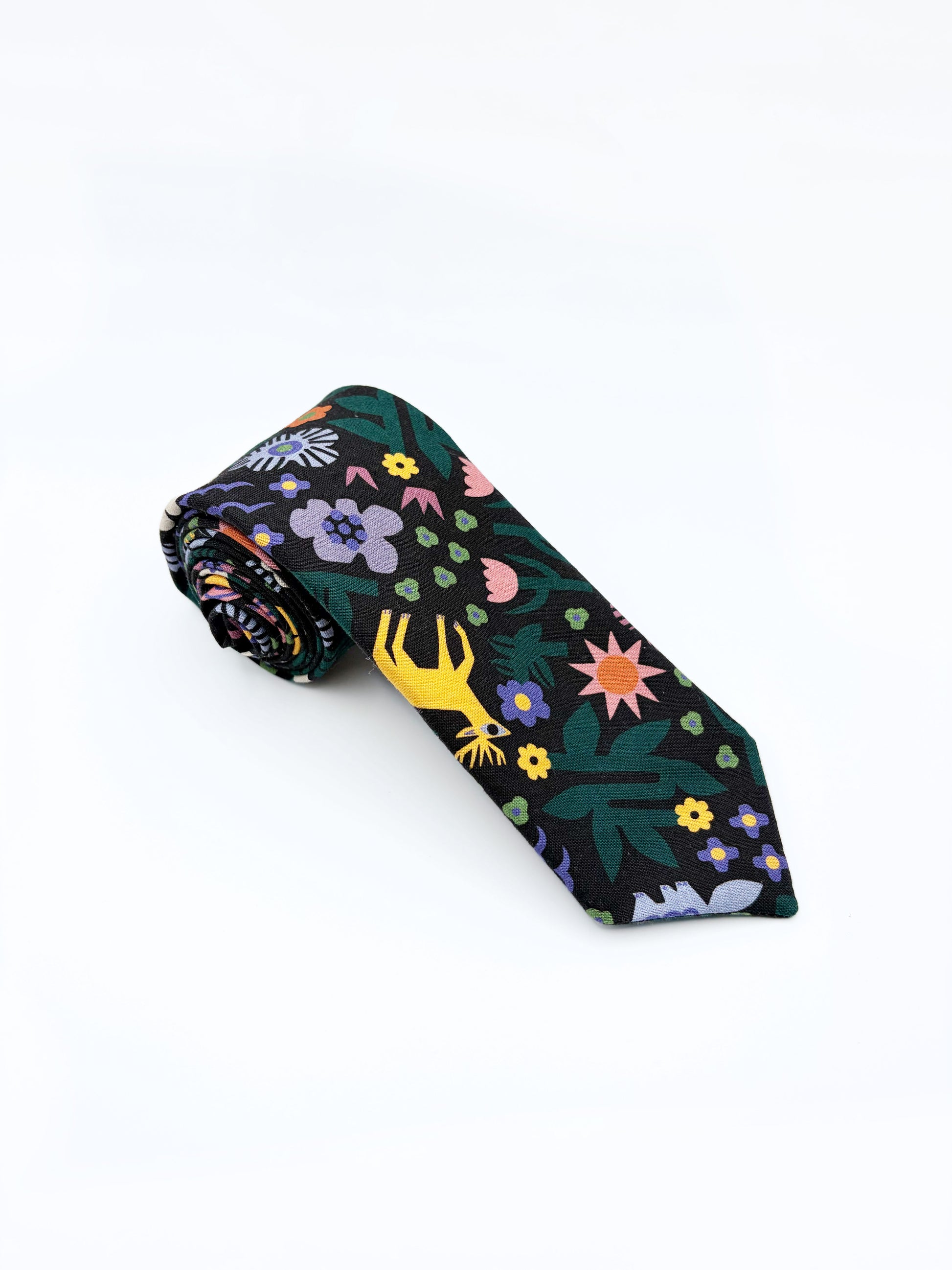 A necktie with an abstract print featuring bright forest creatures and flowers on a black background.