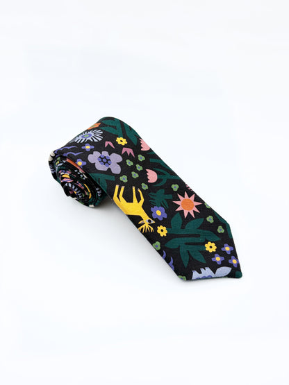 A necktie with an abstract print featuring bright forest creatures and flowers on a black background.