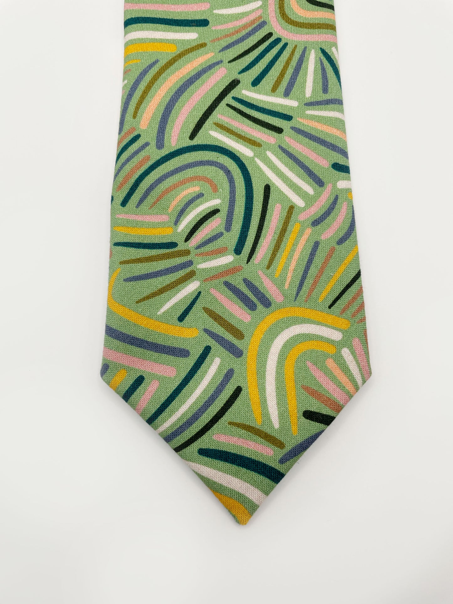 A necktie made from high-quality cotton with an abstract design inspired by desert rain patterns. 