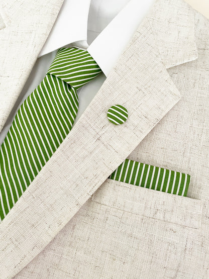 A handmade green necktie with white stripes worn with a matching pocket square and lapel pin.