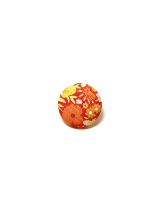 Handmade orange floral fabric covered lapel pin.