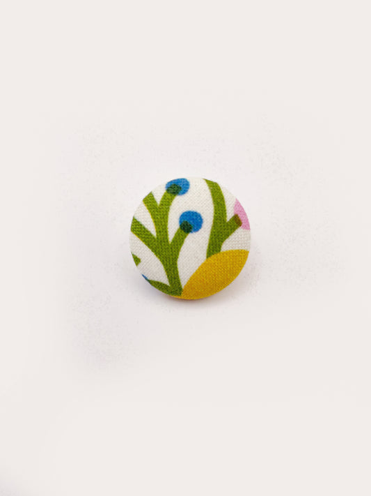 Handmade fabric-covered pins with bold yellow, orange, and pink flowers. 