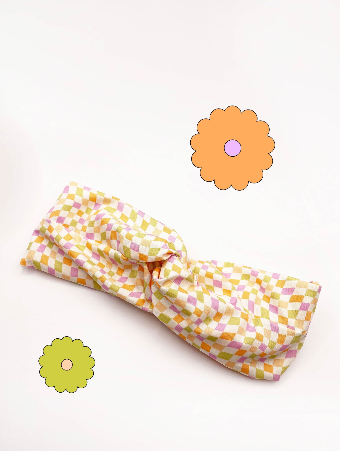 A handmade twist headband with a pastel checkered print. 